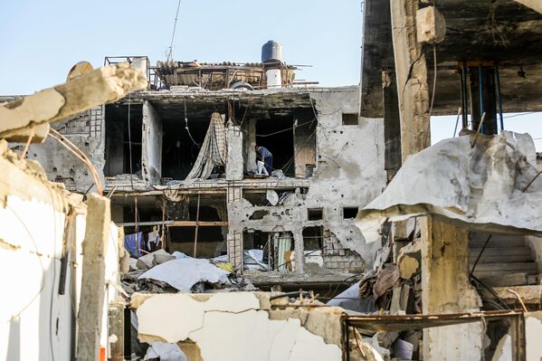 فلسطينيون بين أنقاض منازلهم في خان يونس في قطاع غزة - سبوتنيك عربي