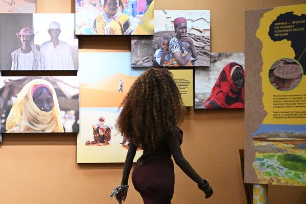 فتاة تنظر إلى مجموعة من الصور في افتتاح معرض "القارة المظلمة، أو رحلة عبر أفريقيا المتعددة الألوان" بمتحف داروين. - سبوتنيك عربي