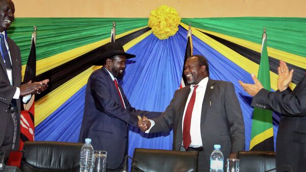 South Sudan's President Salva Kiir, left, shakes hands with rebel leader and former vice president Riek Machar - سبوتنيك عربي