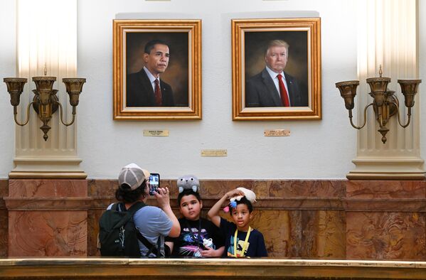 كريستينا غوميز تلتقط صورة لابنها ليون وصديقه، تحت صورة الرئيس السابق باراك أوباما، والرئيس الحالي دونالد ترامب، في القاعة المستديرة من مبنى الكابيتول في ولاية كولورادو، الولايات المتحدة. - سبوتنيك عربي