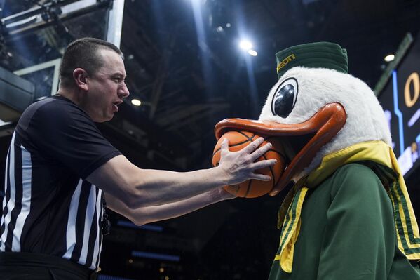 حكم يمازح شخصا يرتدي زي البطة لاستعادة الكرة خلال بطولة الرابطة الوطنية لرياضة الجامعات لكرة السلة في سياتل، الولايات المتحدة. - سبوتنيك عربي