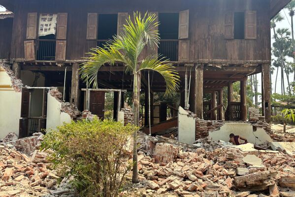 راهب بوذي يبحث عن أغراضه بين الركام، بالقرب من مبنى متضرر في دير للرهبان، عقب الزلزال في نايبيداو، ميانمار - سبوتنيك عربي