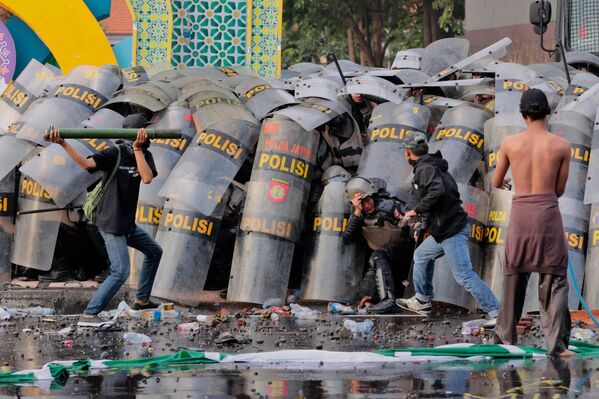 اشتباكات بين المتظاهرين وشرطة مكافحة الشغب، خلال مظاهرة ضد تعديل للقانون عسكري في سورابايا، إندونيسيا. - سبوتنيك عربي