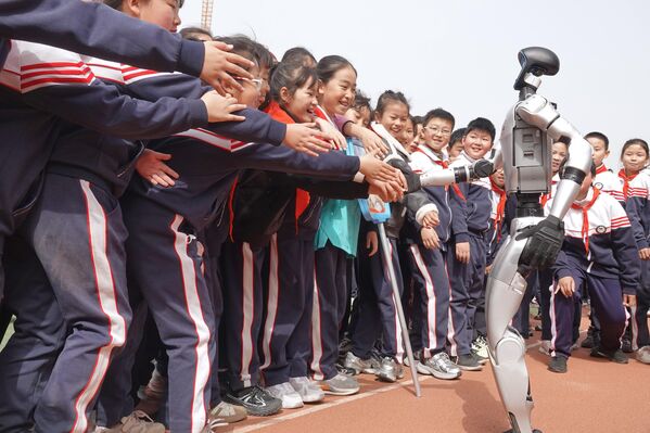 طلاب يصطفون لمصافحة روبوت بشري في مدرسة ابتدائية في يانتاي، مقاطعة شاندونغ، الصين. - سبوتنيك عربي