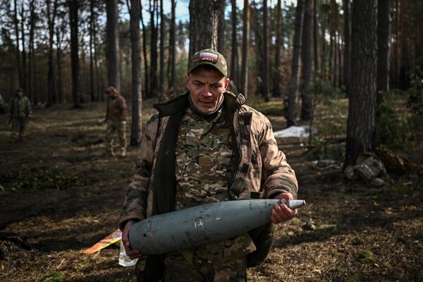 جندي يحمل قذيفة لمدفع هاوتزر "دي-20" التابع لكتيبة القوات الخاصة المنفصلة "أربات" التطوعية في مقاطعة كورسك - سبوتنيك عربي
