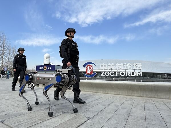 كلب روبوت برفقة ضباط شرطة، يجوب مركز تشونغ غوان تسون الدولي للابتكار،  في بكين، الصين - سبوتنيك عربي