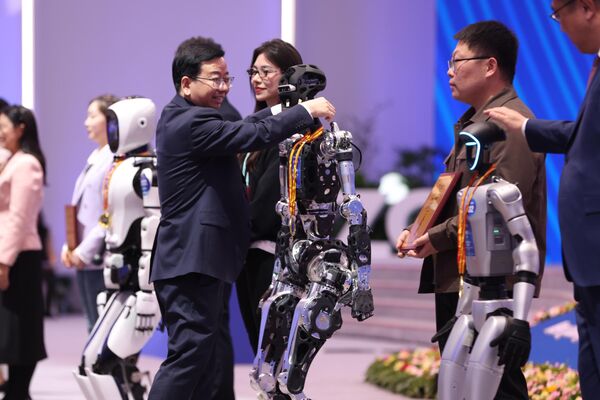 منح الروبوتات ميداليات تذكارية في مؤتمر صحفي خاص للإنجازات، خلال منتدى "تشونغ غوان تسون 2025"، في بكين، الصين - سبوتنيك عربي