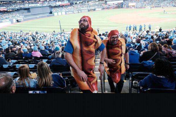 صورة طريفة لعشاق فريق "تورنتو بلو غايز" يرتدون زيا على شكل هوت دوغ. - سبوتنيك عربي