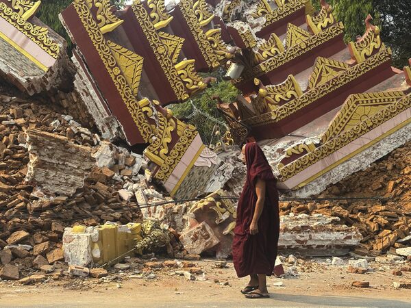 راهب بوذي يسير بالقرب من معبد منهار بعد زلزال في ماندالاي، وسط ميانمار. - سبوتنيك عربي