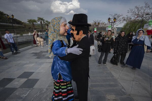 رجلان يرتديان زي رجل وامرأة إيرانيين تقليديين، ويؤديان رقصة في احتفالية العلم، احتفالًا باليوم الوطني للجمهورية الإسلامية الإيرانية، في منطقة عباس آباد الثقافية والسياحية بوسط طهران، إيران. - سبوتنيك عربي