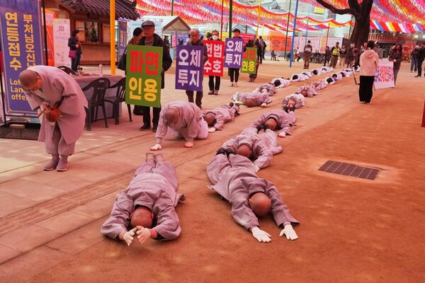 الرهبان البوذيون وأعضاء الجماعات المدنية يسجدون أثناء توجههم إلى المحكمة الدستورية للمطالبة بإقالة الرئيس المعزول يون سوك يول في سيول، كوريا الجنوبية. - سبوتنيك عربي