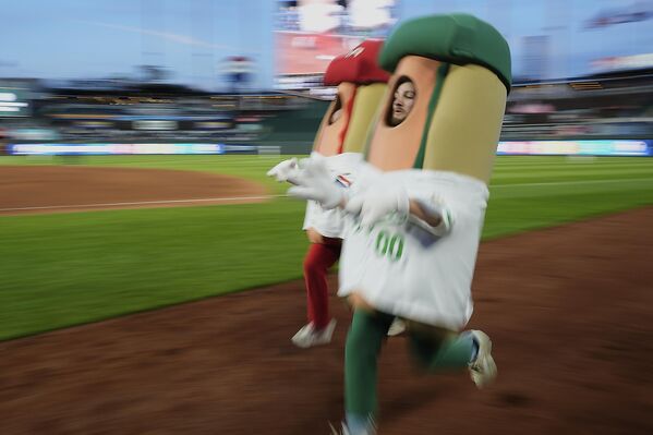 مشجعون يرتدون زي "هوت دوغ" خلال مباراة بيسبول بين فريق كانساس سيتي رويالز، وفريق مينيسوتا توينز، بولاية ميسوري، الولايات المتحدة. - سبوتنيك عربي