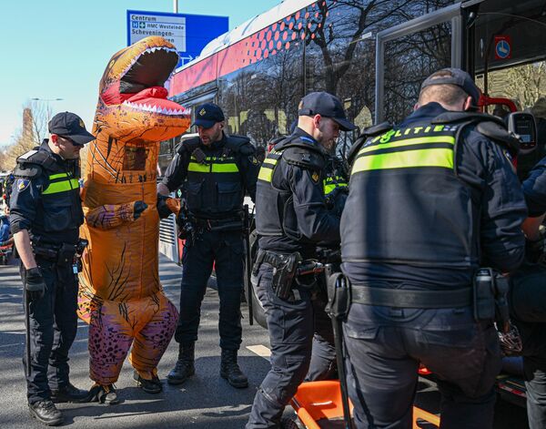 الشرطة تعتقل متظاهرًا يرتدي زي ديناصور خلال مظاهرة في لاهاي، هولندا. - سبوتنيك عربي