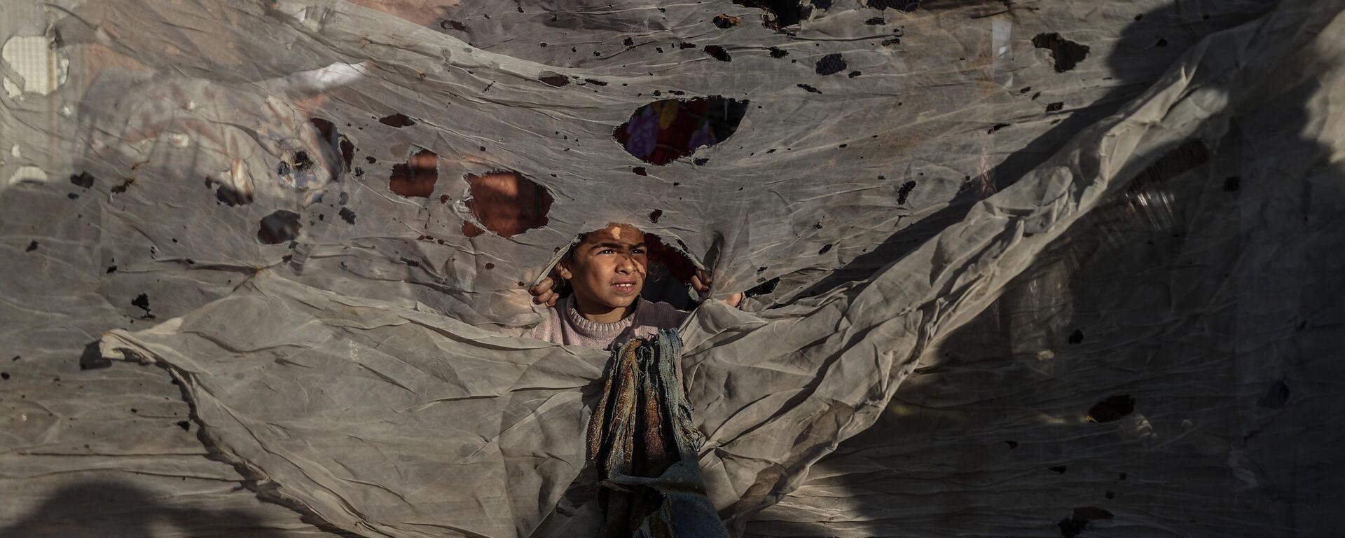 فلسطينيون يتفقدون المنطقة المتضررة بعد أن أصابت غارة جوية إسرائيلية خيامًا تؤوي المدنيين النازحين في خان يونس، غزة - سبوتنيك عربي, 1920, 13.05.2025