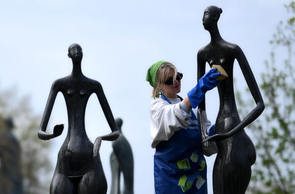 فتاة روسية تقوم بتنظيف تماثيل في حديقة "موزيون" في موسكو. - سبوتنيك عربي