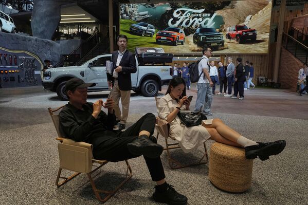 زوار في جناح شركة "فورد" الأمريكية لصناعة السيارات يأخذون قسطا من الراحة، في معرض شنغهاي للسيارات. - سبوتنيك عربي