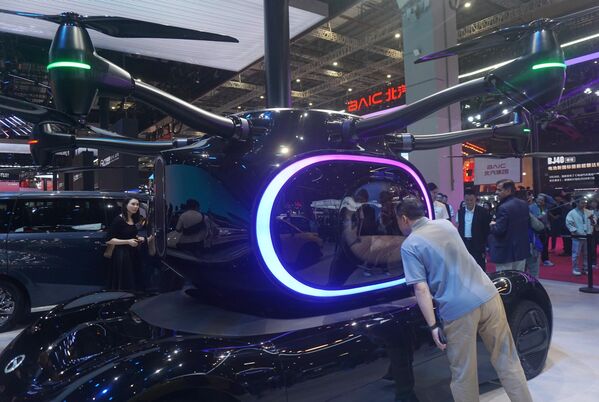 زوار يتفحصون طائرة عمودية كهربائية من طراز "eVTOL" في جناح شركة "GAC" خلال الدورة الحادية والعشرين لمعرض شنغهاي الدولي لصناعة السيارات (أوتو شنغهاي 2025). - سبوتنيك عربي