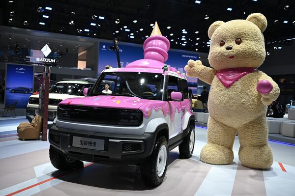 سيارة من العلامة التجارية الصينية "باوجون" تقف على منصة عرض، وعلى سقفها مخروط آيس كريم. - سبوتنيك عربي