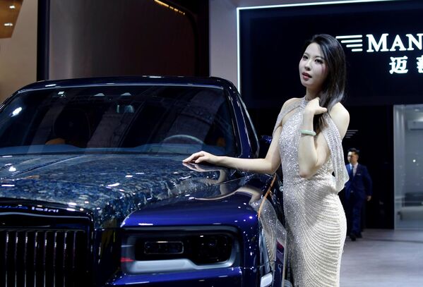 فتاة تستعرض إحدى السيارات الصينية الفاخرة، في معرض شنغهاي للسيارات 2025.  - سبوتنيك عربي