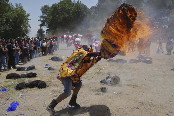 أحد المحتفلين يحاول إخماد حريق أشعله في قبعة من الورق، كجزء من احتفالات عيد الفصح في تيتلا ديل فولكان، المكسيك. - سبوتنيك عربي