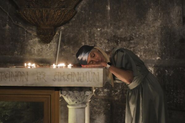 مصلية تستريح أثناء الصلاة خلال قداس عيد الفصح في كنيسة القيامة، في البلدة القديمة بالقدس. - سبوتنيك عربي