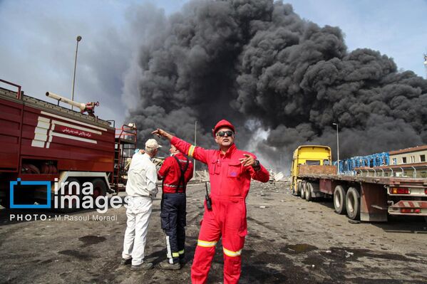 رجال الإطفاء يحاولون إخماد النيران بعد انفجار ميناء رجائي في إيران.  - سبوتنيك عربي