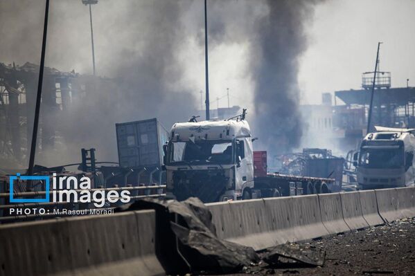 مشاهد تظهر سيارات متفحمة ومحترقة بعد إخماد النيران في المنطقة على أحد الطرقات داخل ميناء رجائي في إيران.  - سبوتنيك عربي