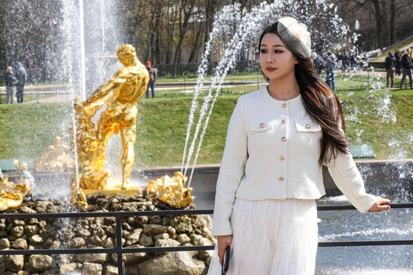 فتاة تلتقط صورة أمام نوافير  متحف "بيترهوف"، خلال افتتاح "موسم النوافير" الصيفي. - سبوتنيك عربي