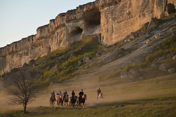 صورة تظهر عددا من الأشخاص يركبون الخيل على امتداد الصخرة البيضاء في بيلوغورسك في شبه جزيرة القرم. - سبوتنيك عربي