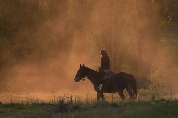 فتاة تركب الخيل وتستمتع بخوض تجربة التجول بين سحر الطبيعة. - سبوتنيك عربي