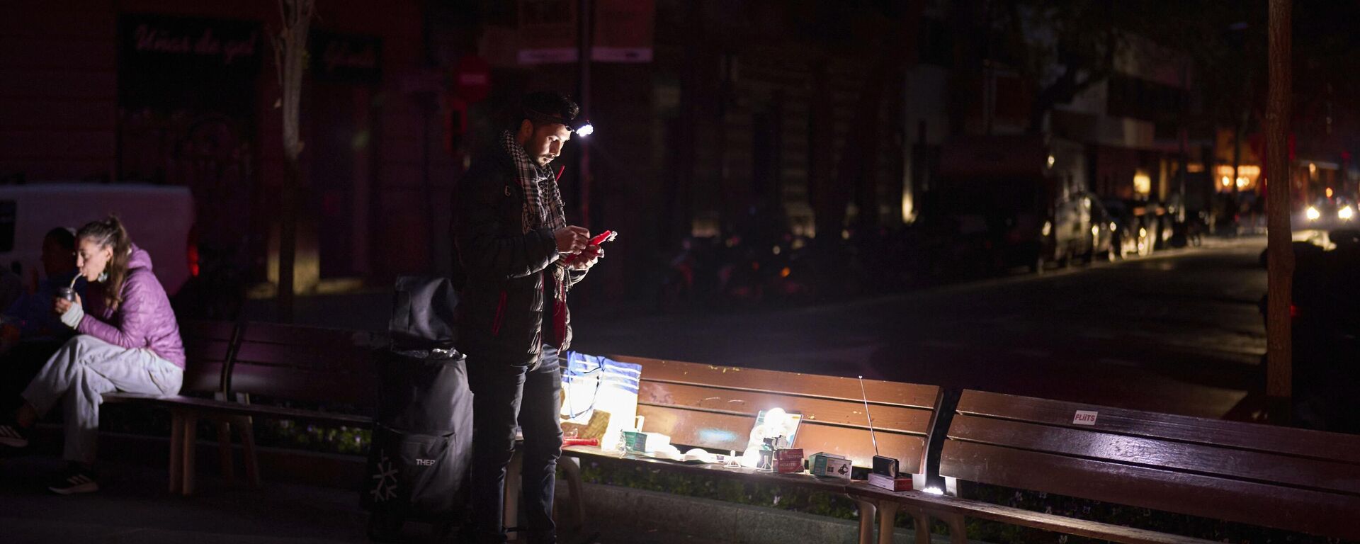 رجل يبيع أجهزة راديو تعمل بالبطارية ومصابيح يدوية في أحد شوارع برشلونة أثناء انقطاع التيار الكهربائي  - سبوتنيك عربي, 1920, 29.04.2025