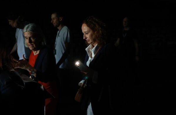 انقطاع الكهرباء يجبر الناس على استخدام مصباح هواتفهم للمشي عبر الممرات المظلمة أثناء حضورهم  بطولة موتوا مدريد المفتوحة للغولف. - سبوتنيك عربي