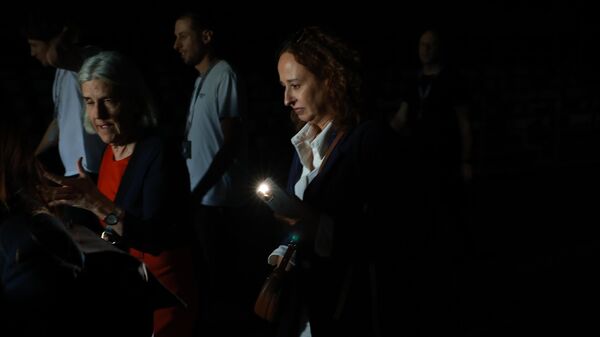 Люди используют свои телефонные фонарики, чтобы пройти по темным проходам во время общего отключения электроэнергии в седьмой день Mutua Madrid Open - سبوتنيك عربي