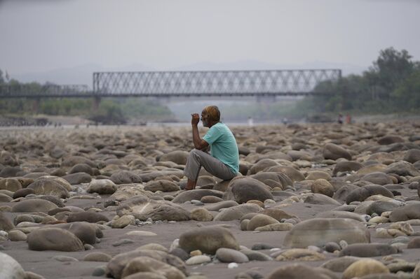 رجل يجلس على ضفة نهر تشيناب ويراقب بحسرة حال النهر. - سبوتنيك عربي