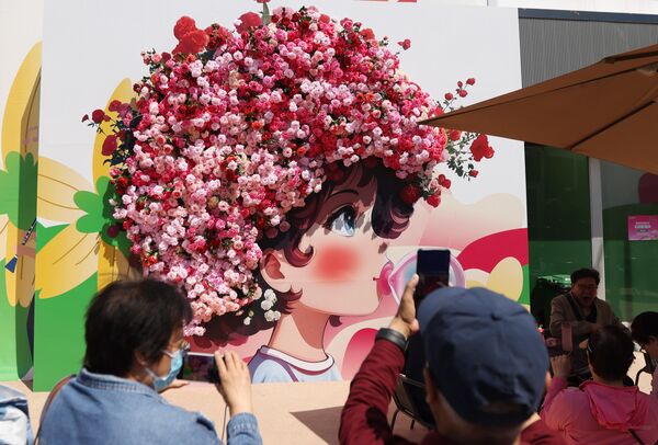 يلتقط الزوار الصور في أجنحة المعرض، التي تعرض أكثر من 1000 نوع من الورود من جميع أنحاء العالم، خلال المؤتمر الدولي للورود في بكين، الصين  - سبوتنيك عربي