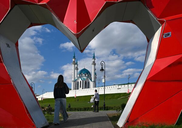 زوار يسترخون بالقرب من الكرملين الموجود في مدينة قازان. - سبوتنيك عربي
