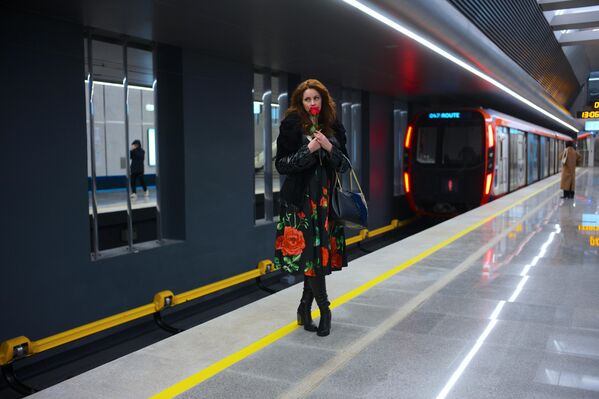 فتاة تقف في محطة مترو "تكستيلشيكي" وبيدها وردة في مترو موسكو - سبوتنيك عربي