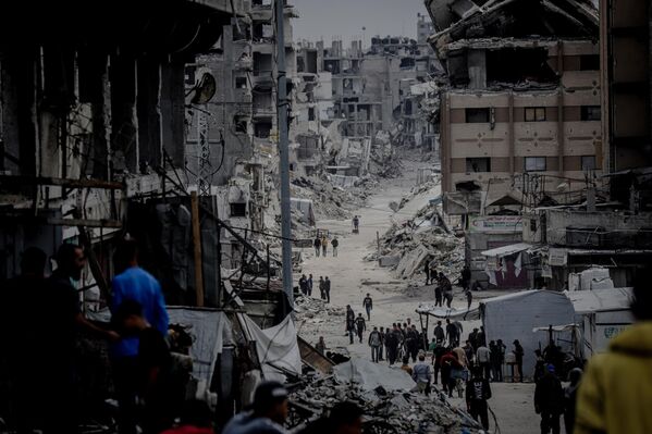 يواصل الفلسطينيون حياتهم اليومية بين أنقاض حي الشجاعية في مدينة غزة، الذي تعرض لأضرار بالغة جراء الهجمات الإسرائيلية المستمرة في 12 مايو/أيار 2025. - سبوتنيك عربي