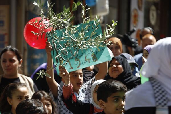 أطفال يحملون أغصان زيتون في دعوة للسلام في القطاع وسائر فلسطين المحتلة. - سبوتنيك عربي