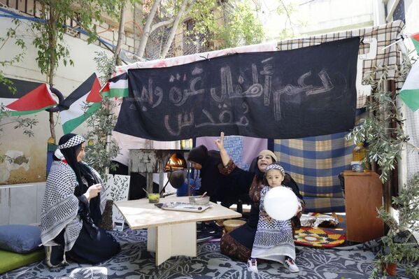 المشاركون يرفعون الأعلام الفلسطينية ولافتة لدعم أطفال غزة. - سبوتنيك عربي