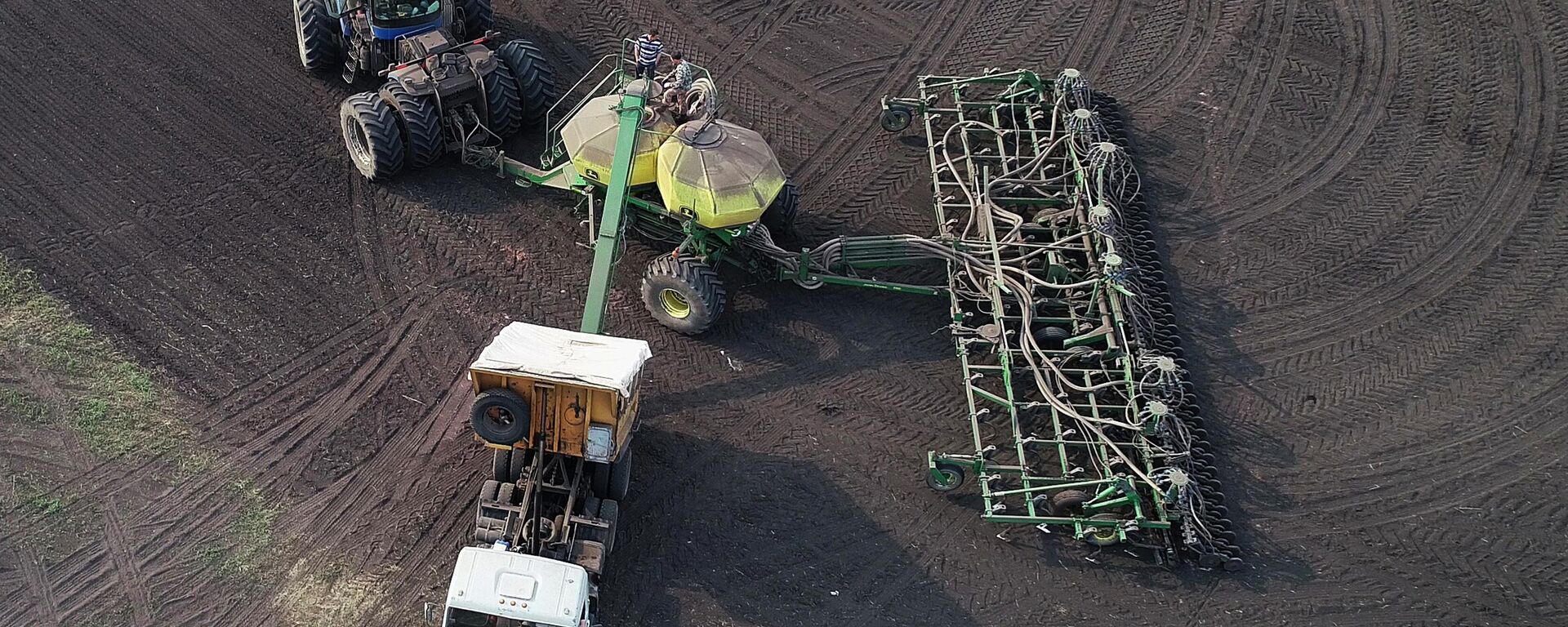 نقل الأسمدة من المركبة إلى مخزن مجمع البذور أثناء زراعة القمح في روسيا - سبوتنيك عربي, 1920, 25.05.2025