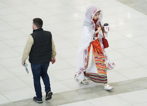 مشاركة تسير وهي ترتدي الزي التقليدي خلال أعمال المنتدى الاقتصادي الدولي السادس عشر &quot;روسيا - العالم الإسلامي: منتدى قازان 2025&quot; - سبوتنيك عربي