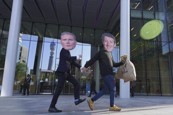 نشطاء من تحالف "أوقفوا ترامب" يرتدون قناع مارك زوكربيرغ ، وقناع رئيس الوزراء البريطاني كير ستارمر، أثناء احتجاج في لندن للمطالبة بفرض ضرائب أعلى على شركات التكنولوجيا الكبرى - سبوتنيك عربي