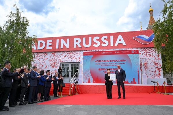 نائب رئيس الوزراء الروسي ديمتري تشيرنيشينكو، والمدونة الصينية يانغ رونغشين، التي حصلت على إشادة لمساهمتها في تطوير العلاقات التجارية والاقتصادية الروسية الصينية، في معرض "صنع في روسيا" الدولي للمبيعات عبر الإنترنت للعلامات التجارية الروسية في حديقة "زارياديه" في العاصمة موسكو - سبوتنيك عربي