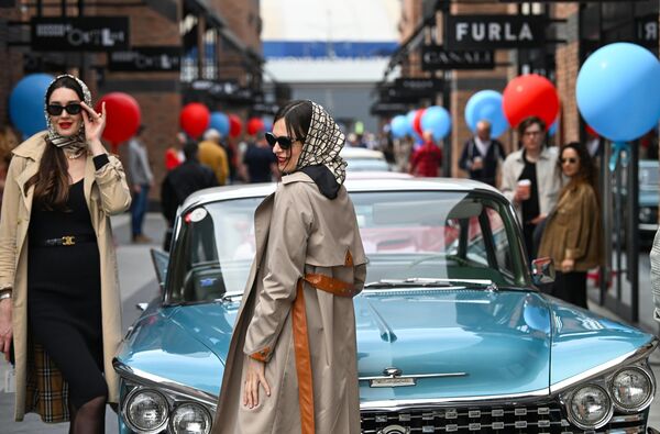 فتيات يقفن أمام مجموعة من السيارات الكلاسيكية في التجمع السنوي للسيارات الكلاسيكية على أراضي مجمع التسوق "أرخانغيلسكوي أوتليت" - سبوتنيك عربي