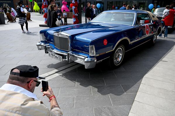 مجموعة من الزوار يصورون السيارات القديمة في التجمع السنوي للسيارات الكلاسيكية على أراضي مجمع التسوق "أرخانغيلسكوي أوتليت" - سبوتنيك عربي