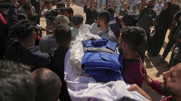 نقل جثمان الصحفي الفلسطيني يحيى صبيح، الذي قُتل مع 28 آخرين على الأقل في غارة للجيش الإسرائيلي على مطعم، إلى مستشفى الشفاء في مدينة غزة، الأربعاء 7 مايو/أيار 2025. - سبوتنيك عربي