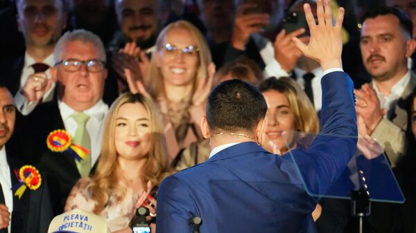 المرشح الرئاسي جورج سيميون يلوح لأنصاره بعد إغلاق صناديق الاقتراع للجولة الثانية من الانتخابات الرئاسية المعادة في بوخارست، رومانيا، الأحد 18 مايو/أيار 2025. - سبوتنيك عربي