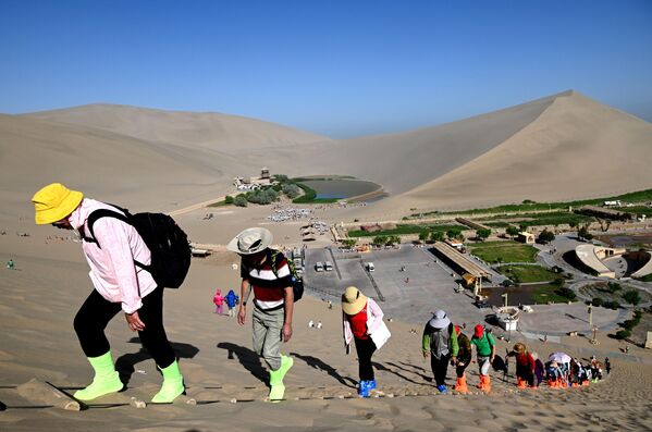 سياح يتسلقون تلة مطلة على مدينة دونهوانغ، لمشاهدة طريق الحرير - سبوتنيك عربي