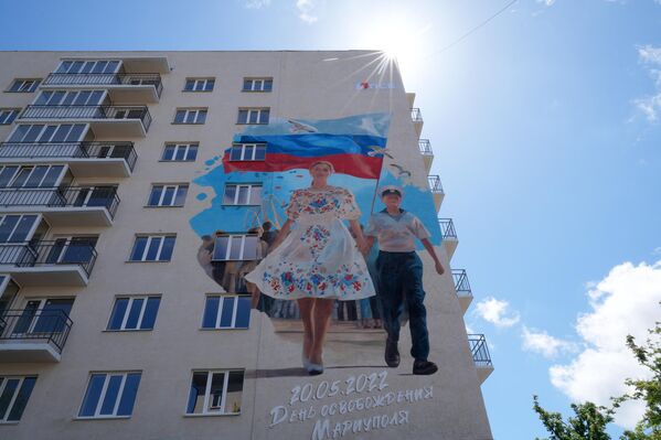 لوحة جدارية رسمت على إحدى المباني عشية الذكرى الثالثة لتحرير ماريوبول. - سبوتنيك عربي